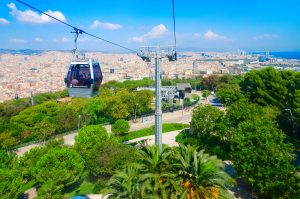 Tourists descend in cabin of cable car (Teleferic de Montjuic) from mountain of Montjuïc, Barcelona, Spain
